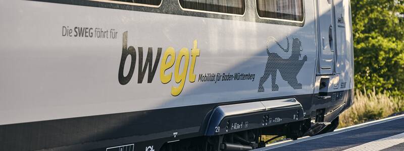 Ein Zug mit der Aufschrift "bwegt" und einem Löwen-Logo steht am Bahnsteig.